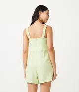 Enterito corto color verde claro, con escote en V, tirantes anchos y detalle de ondas en el frente.