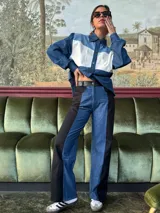 Pantalón de tiro alto con pierna ancha, confeccionado en denim azul y cuerina negra.