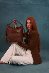 Mochila cartera de símil cuero color marrón, con compartimento principal amplio y bolsillos frontales con cierre. Cuenta con correas ajustables y asa superior para llevar al hombro o como mochila.