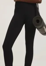 Calza deportiva de tiro alto con textura acanalada, confeccionada en tejido elástico de color verde oscuro.