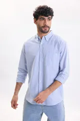 Camisa de lino de manga larga con diseño a rayas en color azul claro y blanco, cuello abotonado y cierre frontal de botones.