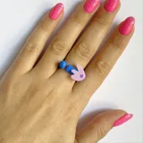 Anillo ajustable con forma de conejo color lila y detalles en azul.