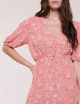 Vestido corto de calce fluido con escote en V y mangas cortas abullonadas. Presenta cintura elastizada con cordón ajustable y falda con volados en el borde inferior.