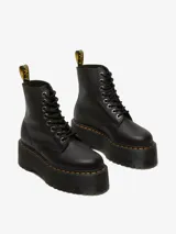 Botas Dr. Martens modelo 1460 Pascal Max de cuero negro, con plataforma gruesa acanalada, cordones negros, ojales metálicos plateados y costuras amarillas distintivas. Incluye tirador trasero con logo en amarillo y negro.
