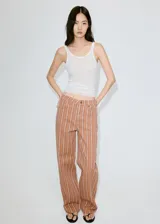 Jeans de corte recto en color marrón con diseño de rayas verticales blancas, tiro medio y estilo clásico de cinco bolsillos.