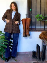 Blazer de paño de lana en color marrón con diseño de cuadros grandes en tonos claros. Presenta solapas clásicas con detalle de costura, cierre frontal con un botón y bolsillos laterales. El corte es recto y estructurado.