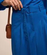 Pollera midi de corte recto color azul, confeccionada en viscosa, con pliegues delanteros y cinturón incorporado con hebilla.