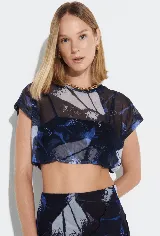 Blusa corta de malla traslúcida con estampado abstracto en tonos azul, negro y gris.