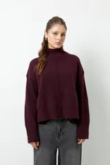 Polera de cuello alto confeccionada en tejido de punto, con manga larga y costura central decorativa en el frente.