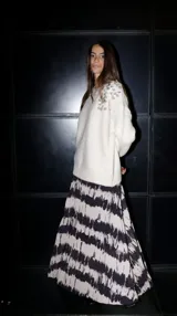 Buzo color crema de punto con escote redondo y lentejuelas bordadas en los hombros.