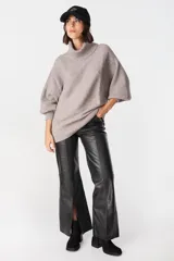 Sweater de punto con textura acanalada, cuello alto tipo polerón, mangas largas con diseño abuchonado y puños anchos.