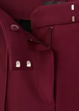 Pantalón de tiro medio color bordó, de diseño recto y largo, con trabillas para cinto y cierre oculto.