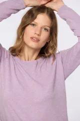 Buzo tejido en hilo de algodón color lila, con cuello redondo clásico y manga larga. Presenta pequeños puntos amarillos distribuidos por toda la prenda.