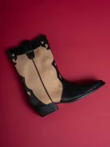 Botas de caña baja color negro con detalles en beige y cierre lateral.