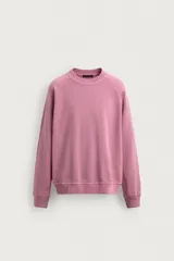 Sudadera regular fit confeccionada en tejido de algodón. Presenta cuello redondo, manga larga ranglán, efecto lavado y acabados en rib.