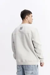 Buzo de algodón color marrón chocolate, con cuello redondo, mangas largas y estampa frontal con el nombre de la marca repetido en tono sobre tono.