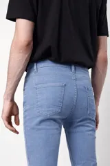 Pantalón de jean en tono celeste claro, con corte skinny fit, bolsillos laterales y traseros, y cierre frontal con botón.
