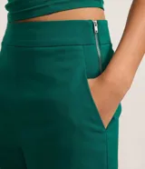 Short corto marrón de bengalina con bolsillos delanteros y cierre lateral, tiro medio y corte ajustado.
