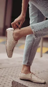 Zapato de cuero marrón chocolate con cordones finos negros, punta cuadrada y detalles de perforaciones decorativas en los laterales.