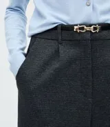 Pantalón de corte recto confeccionado en punto roma con estampado de cuadros. Presenta cintura estructurada con pliegues delanteros, trabillas para cinturón y cierre frontal. Incluye un cinturón fino con hebilla metálica.