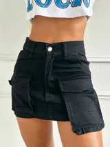 Minifalda negra de gabardina con bolsillos cargo laterales y cierre frontal con botón metálico.