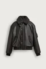 Cazadora relaxed fit de cuero sintético negro con cuello de corderito sintético desmontable, bolsillos frontales con solapa, bolsillo en la manga y cierre frontal con botones a presión y cremallera.