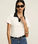 Blusa acanalada de manga corta con textura en rib, color blanco con cuello polo contrastante en color negro.
