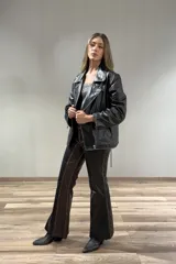 Pantalón de cuero marrón oscuro, de corte acampanado, con detalles de costuras en contraste y efecto desgastado.