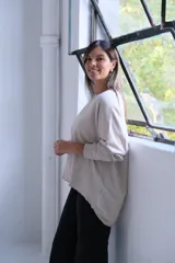Sweater de punto color beige, de corte holgado y diseño minimalista con cuello redondo y mangas largas.