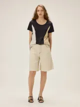 Bermuda de calce relajado de color beige, con bolsillos traseros y pespuntes a contra tono.