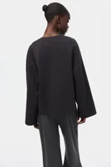 Buzo oversized de punto interlock pesado en color negro, con cuello redondo y mangas largas amplias.