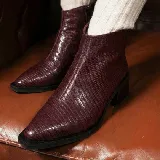 Bota corta de cuero vacuno con acabado metalizado y textura de reptil. Presenta punta fina, cierre lateral interno y taco cuadrado de madera.