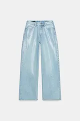 Pantalón jeans de tiro medio, pernera recta y diseño de cinco bolsillos, recubierto de lentejuelas brillantes en tono celeste. Cuenta con cierre frontal de cremallera y botón metálico.