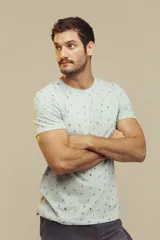 Remera de cuello redondo y manga corta, color beige con estampado de pequeños motivos playeros.