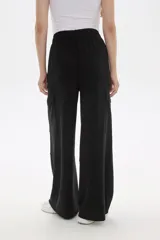 Pantalon de corte amplio y tiro alto, confeccionado en poliester, con bolsillos laterales tipo cargo.