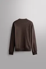 Buzo negro de cuello redondo, corte relaxed fit, confeccionado en tejido de algodón con interior de rizo y acabado en rib.