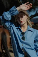 Camisa celeste de jean fino, de corte clásico y mangas largas con puños abullonados.