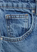 Pantalón de jean celeste de corte slouchy, tiro medio, cinco bolsillos y cierre con cremallera y botón. Confeccionado en tejido de algodón estilo tejano vaquero.
