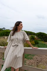 Túnica de corte amplio color beige con rayas verticales blancas, mangas 3/4 y lazo en la cintura.