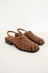 Sandalias de cuero marrón con diseño de tiras trenzadas tipo huarache, punta cuadrada y suela plana con taco bajo.