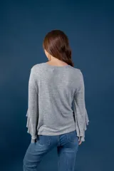 Blusa gris melange de punto tejido fino, con escote en V y mangas largas anchas terminadas en volados.