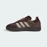 Championes Adidas modelo Samba XLG, de diseño urbano con suela de plataforma. Presentan una combinación de tonos marrones en gamuza y cuero, con las icónicas tres franjas laterales en color beige y detalles en naranja vibrante en la lengüeta y el lateral.