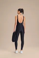 Jumpsuit largo de una pieza, color bordó, con diseño ajustado, escote redondo y tirantes anchos. Confeccionado en tejido con acabado satinado y elástico.