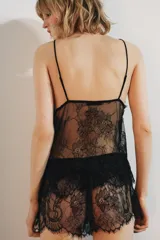 Short de encaje negro semitransparente, de tiro medio, con cintura elástica ajustable con lazada, detalle de volantes y bajo con acabado en ondas.