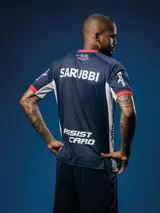 Camiseta de arquero Umbro del Club Nacional de Football, temporada 2025. Diseño en tonos de azul con un estampado gráfico abstracto en el frente, cuello redondo y detalles en rojo en el cuello y los puños de las mangas. Incluye los logos de los sponsors y el escudo del club.
