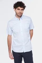 Camisa de manga corta color celeste claro, con cuello abotonado (button-down) y un bolsillo de parche en el pecho.