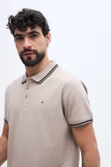 Chomba piqué de manga corta verde militar con cuello y puños tejidos a contratono en tonos claros. Cuenta con cartera de tres botones y pequeño logo bordado en el pecho.