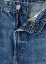 Jeans de denim azul de tiro medio y diseño wide leg largo, con cinco bolsillos, trabillas para cinto y cierre de botón y cremallera.