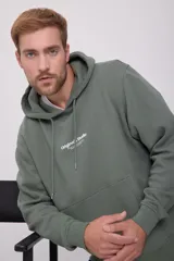 Canguro verde oliva de manga larga con capucha, corte relajado y bolsillo tipo canguro. Estampado con el texto "Originals Studio" en el pecho.