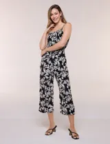 Enterito crop de rayón con estampado geométrico en blanco y negro, busto elastizado con frunces, breteles finos regulables y cordón ajustable en la cintura con terminaciones de borlas. Pantalón de corte amplio y relajado.